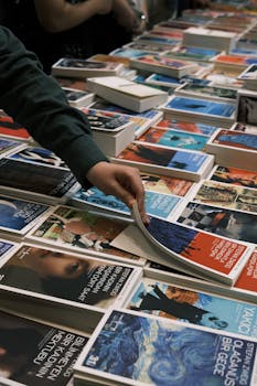 Home Person browsing books at a lively book sale in İzmit, Türkiye.